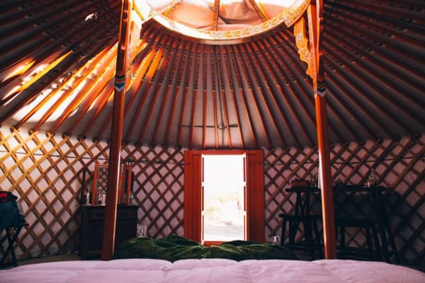 28 Palms Ranch Stargazing Yurt view of inside from bed with door and skylight