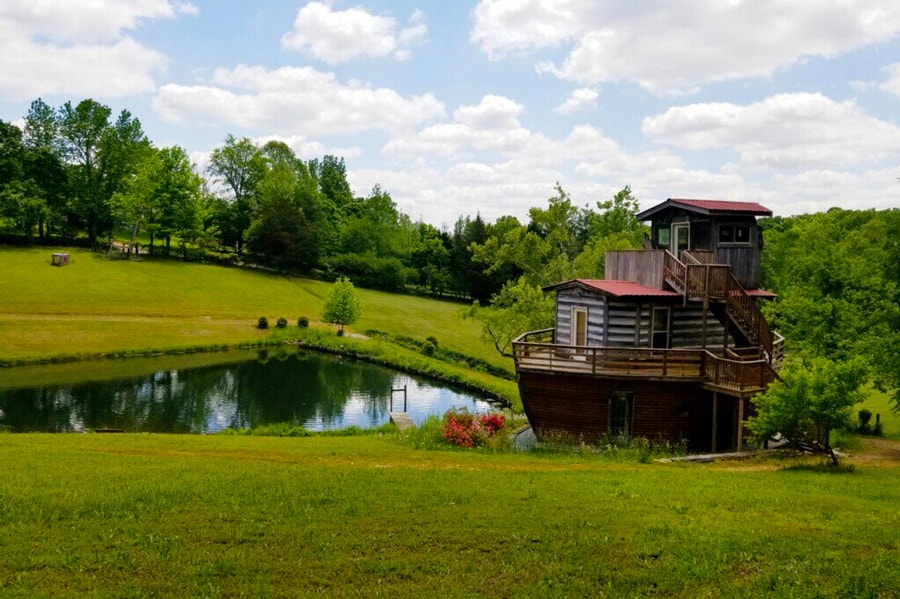 Tennessee Glamping at The Ark  view of the Ark looking cabin next to a pond and green trees and grass