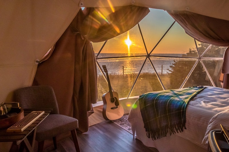 Archer's Edge view from inside with bed, guitar at window with view of the ocean