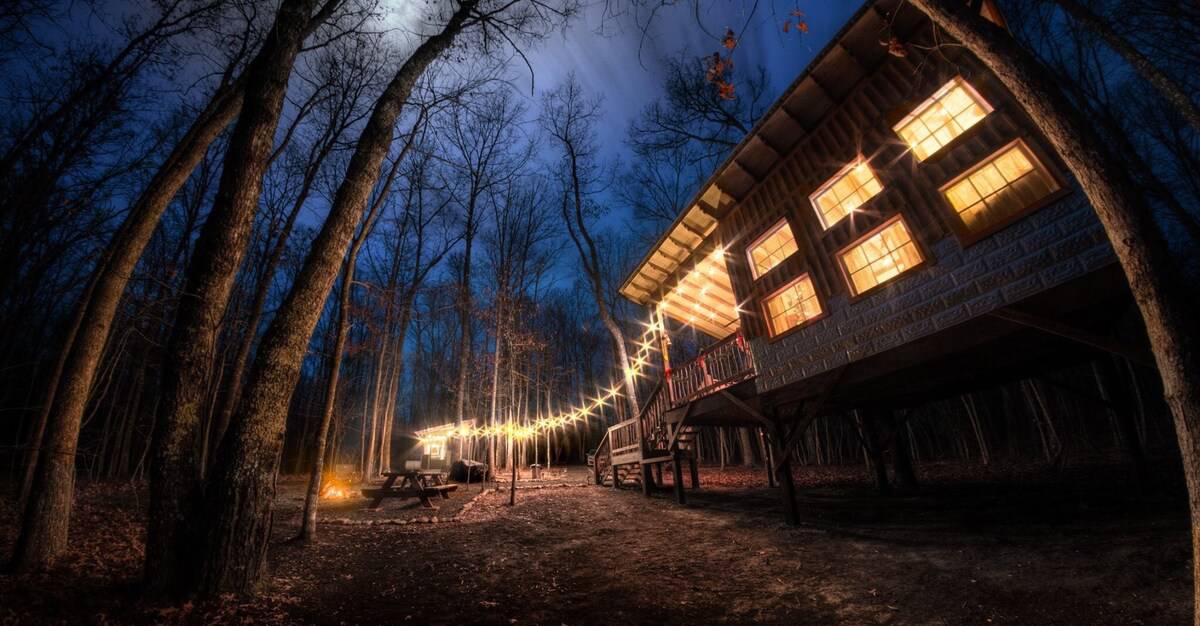 10 best glamping Tennessee Locations view of deer camp glamping at night with lights on