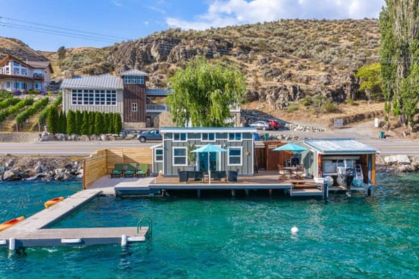 airbnb lake Chelan cabana on the water view of the cabin and dock with the blue water and hill in the background