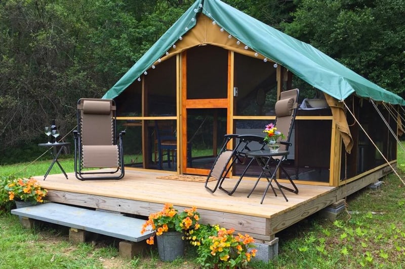 Vermont Glamping tent in Heaven with view of the front wooden porch with chairs and tent open to the air.