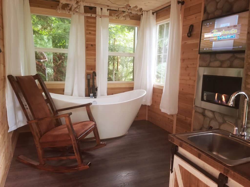 Treehouse in Washington State inside view with fireplace, tv bathtub, chair and sink