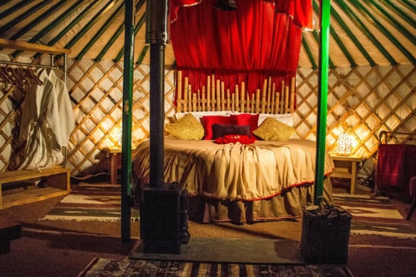 inside of a glamping yurt peak district with round bed and side tables