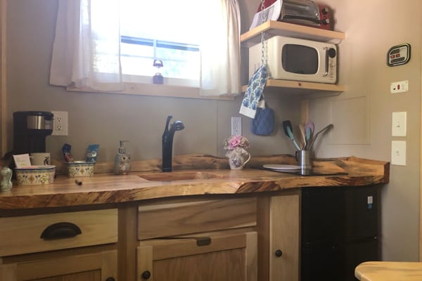 kitchen view with wood counters and a sink with window in a gypsy wagon