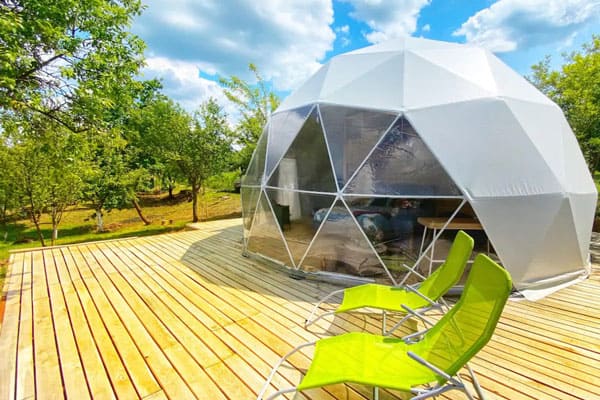 Romania Glamping Dome in Vale with view of deck and white dome with large windows and two chairs
