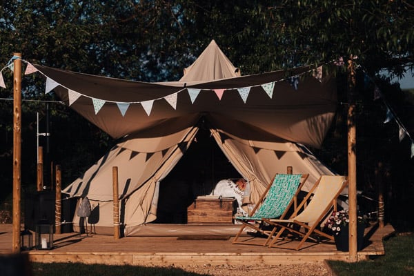 belle glamping tent with deck and chairs