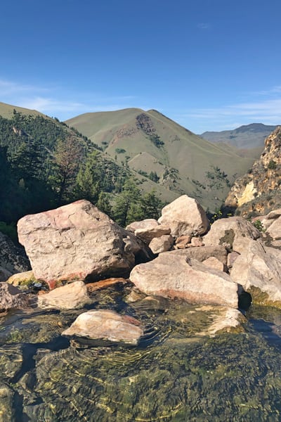 view from Goldbug Hot Springs Trail, pool of water with mountains while glamping in idaho