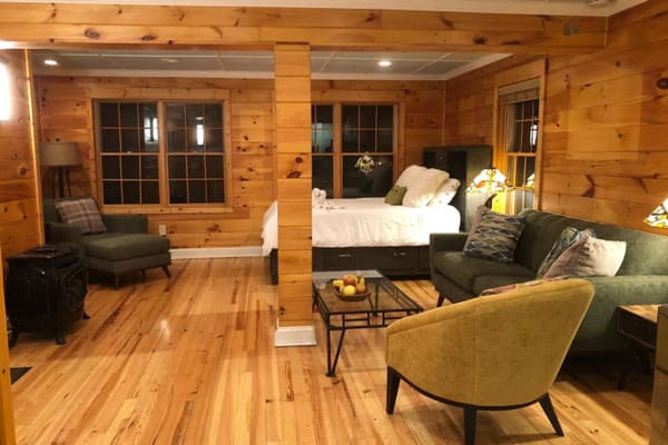 Happy Place Treehouse Black Mountain view of inside with bed, couch and chairs. Wooden walls