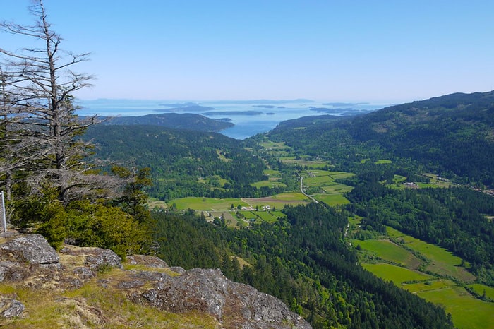 hiking on salt spring island view from a rock with the green valley and gulf islands in the background