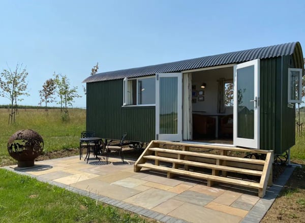 Stunning Lakeside Shepherd's Hut with Hot Tub view of the hit with doors open and chairs and a firepit