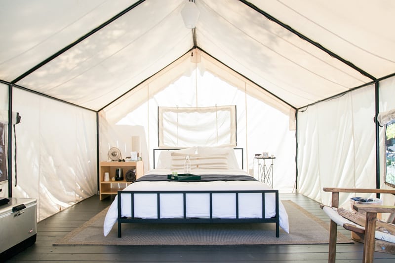 autocamp luxury glamping tent view of inside with bed, chair, nightstand and canvas walls