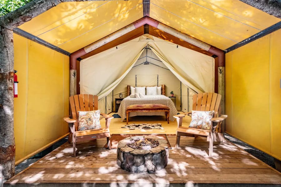 Big Sur California Glamping Tent inside view with bed and chairs and fireplace