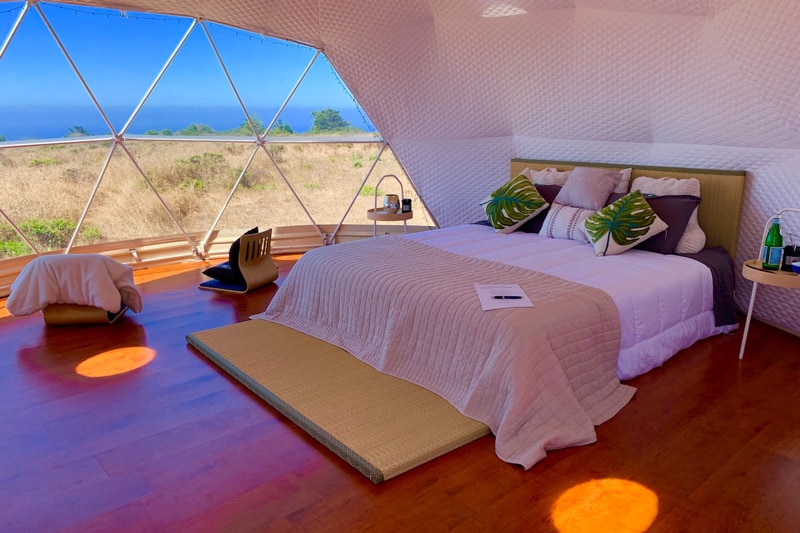 glamping dome bay area view from inside with bed and chairs and large windows with a view