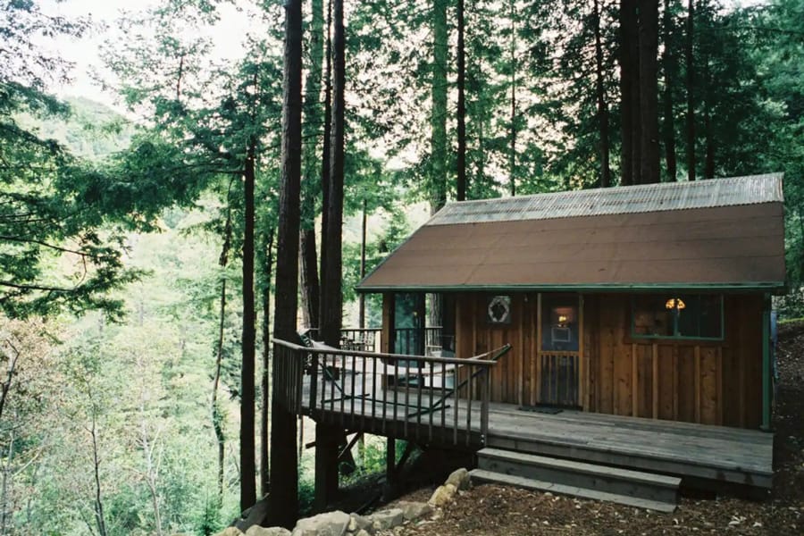 Big Sur Glamping Getaway - Rosehaven  view of cabin with deck looking out over valley with a forest