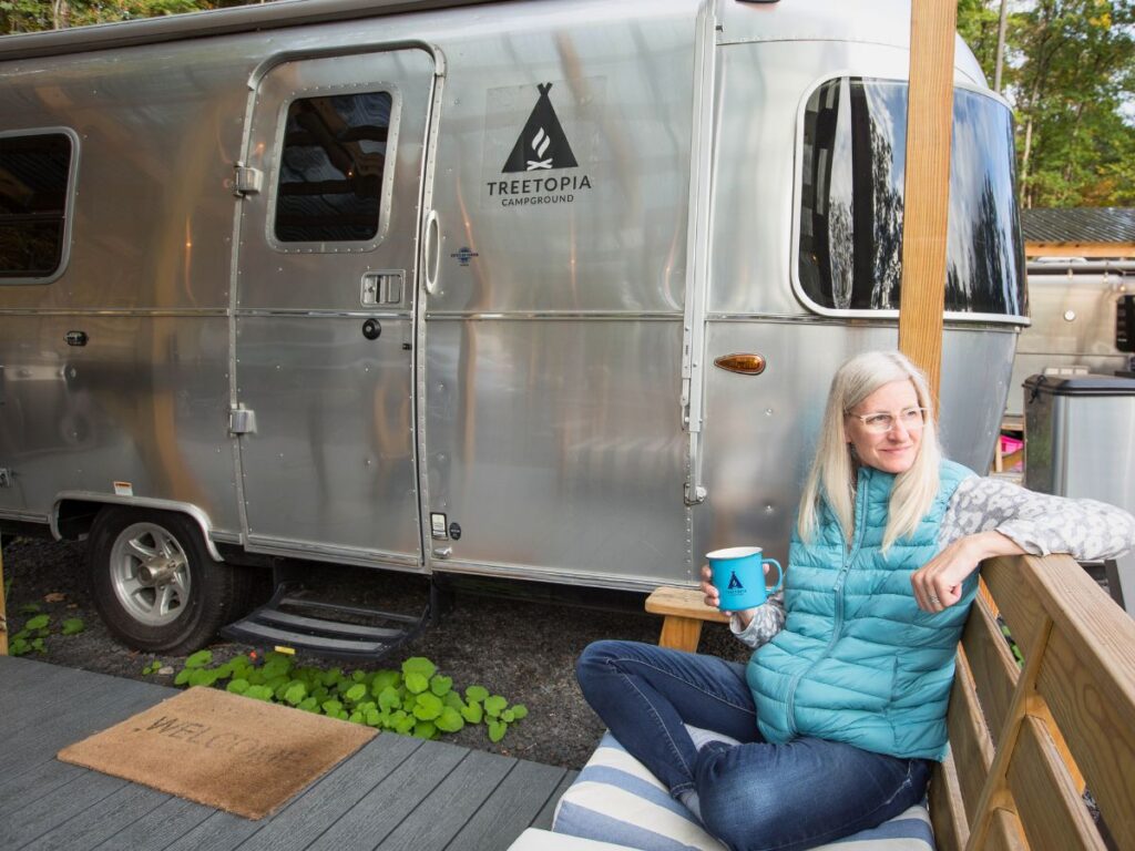 Sage Sipping Coffee Outside Treetopia Airstream Bambi- Photo Credit: Sage Scott