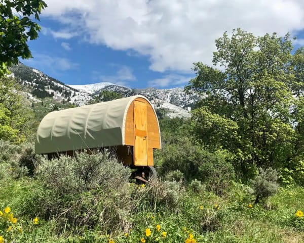 covered wagon Glamping in Idaho spot. View of the outside with mountains in the back