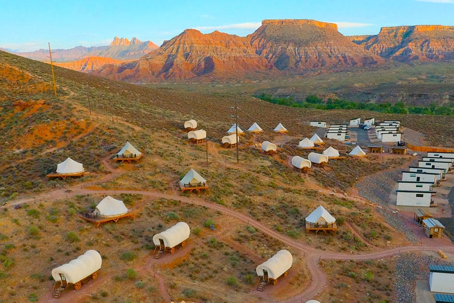 Wildflower Glamping Resort Zion view from above showing covered wagons, bell tents and tiny homes spread out with Zion landscape in the background
