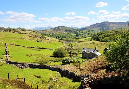 Snowdonia National Park Glamping North Wales View of a cottage with the mountains and fields
