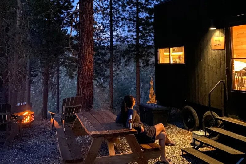 Getaway House Cabin Outside in the evening with table and campfire