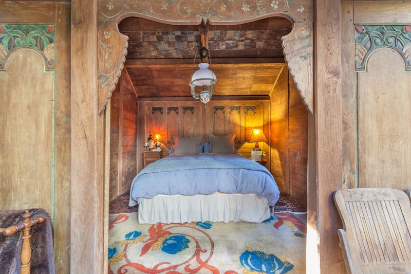 swallowtail glamping hut view of the bedroom with wood carvings and decorations