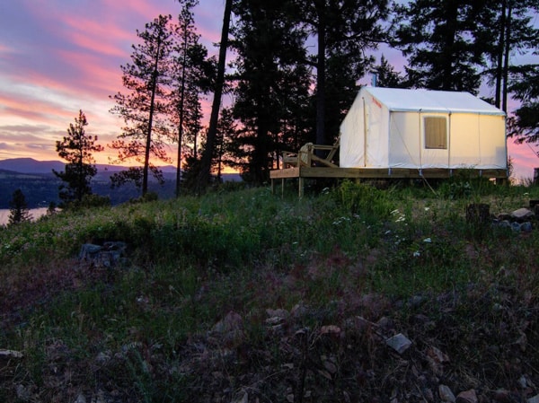 tentrr signature glamping tent in coeur d'alene while Glamping Idaho. View of the outside at sunset with the trees and lake in the background