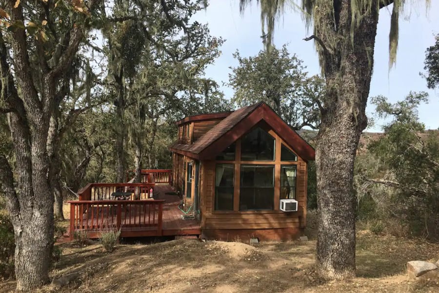 Tassajara Tiny House Glamping Big Sur view of home with front windows, deck and trees around