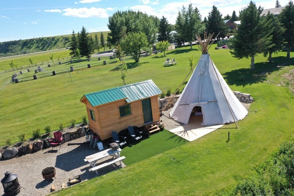 Teepee and Tiny House Experience view from above with tipi and a small tiny home next to it in a grassy field