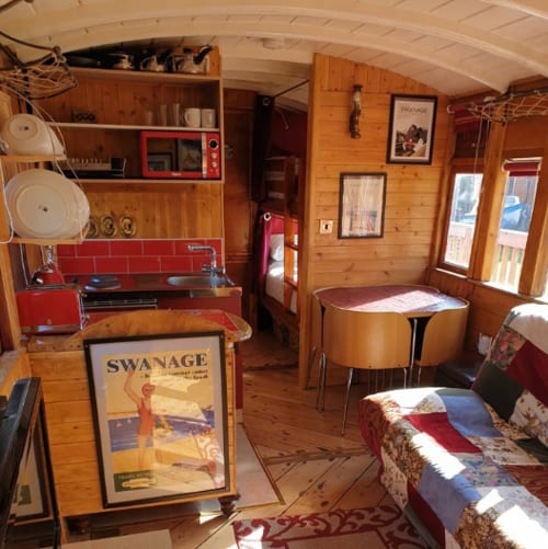 inside view of glamping train in new forest with tables, kitchen and couch and hallway