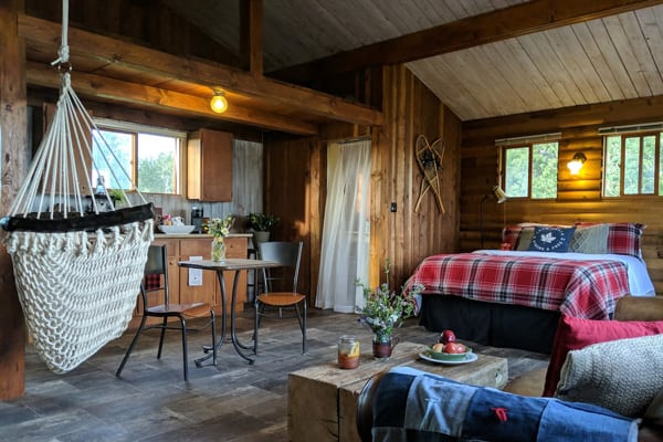 Tranquil Glamping cabin Getaway view of the inside with a bed, kitchen, couch and hammock