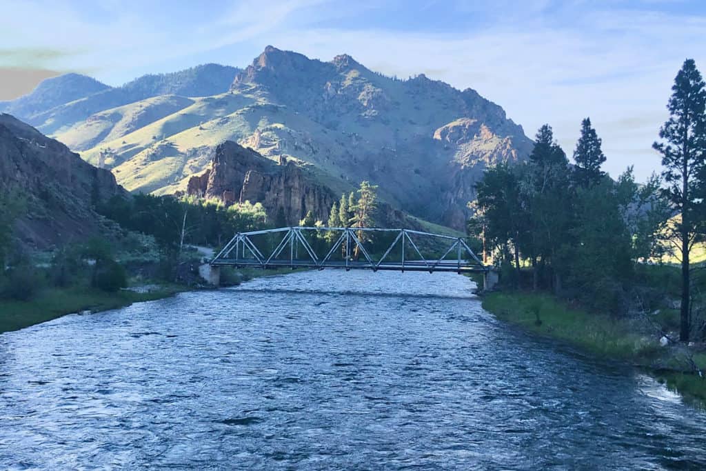 view of bridge with mountains in the back and sun from the left while glamping in idaho