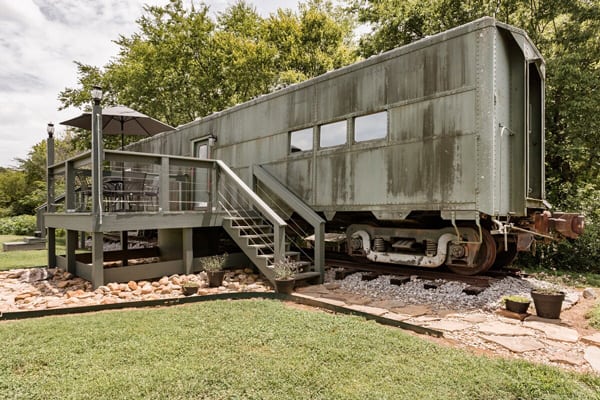 Converted WWII glamping Train Car with Patio outside view with patio and silver train car